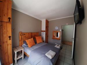 a bedroom with a bed and a flat screen tv at Edaneg in Bloemfontein