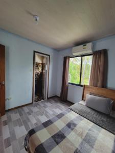 a bedroom with a bed and a large window at Siargao Villaflor Residence in Dapa