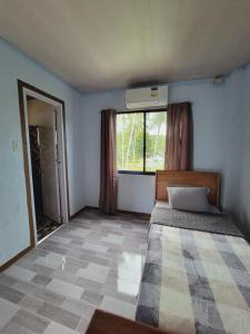 a bedroom with a bed and a large window at Siargao Villaflor Residence in Dapa