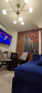 ein Schlafzimmer mit einem Bett, einem Tisch und einem Fernseher in der Unterkunft DEPARTAMENTO EN EQUIPETROL CON PISCINA ATEMPERADA- GYM Y PARQUEO GRATIS, CERCA DEL VENTURA MALL , LOS TAJIBOS, MANZANA 40 y SUPERMERCADOS in Santa Cruz de la Sierra
