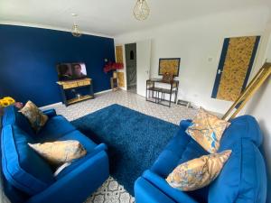 a blue living room with two blue couches at Beautiful Guesthouse in Stratford-upon-Avon