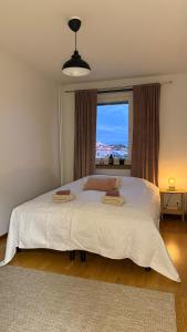 Un dormitorio con una gran cama blanca con ventana. en Viihtyisä kaksio keskustassa, en Kokkola