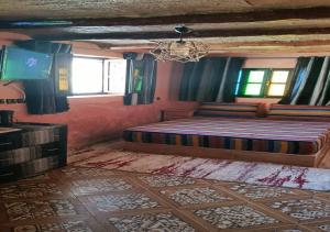a bedroom with a bed and windows and a chandelier at Ferme Panorama in Ouazzane