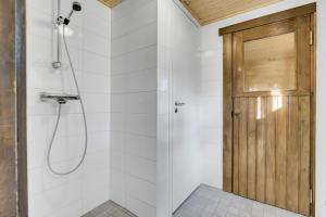 a bathroom with a shower with a wooden door at Laavu 13 Original Log Cabin with Sauna in Pyhätunturi +28 photos