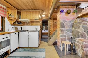 a kitchen with a rock wall and a slide at Laavu 13 Original Log Cabin with Sauna in Pyhätunturi