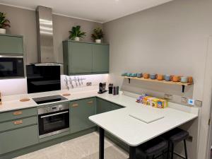 エディンバラにあるBen Cruachan Guest Houseのキッチン(緑のキャビネット、白いカウンタートップ付) +44枚の写真