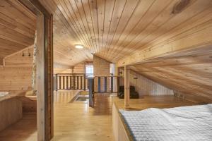 a room with a bed and a wooden ceiling at Laavu 13 Original Log Cabin with Sauna in Pyhätunturi