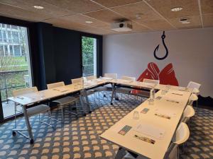 ein Konferenzraum mit Tischen und Stühlen und einem großen Fenster in der Unterkunft ibis Styles Thonon-les-Bains in Thonon-les-Bains