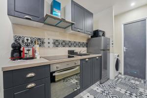 a kitchen with a sink and a refrigerator at Appartement RDC avec parking au centre-ville in Charleville-Mézières