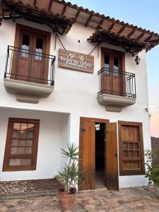 a white building with two balconies and two doors at Recanto das Libélulas Pousada in Tiradentes