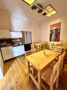 a dining room with a wooden table and a kitchen at Casa Grau in Sucre