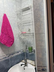 a bathroom with a sink and a pink towel at Mehrz Apartments in Baku +2 photos