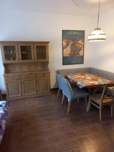 a dining room with a table and a wooden cabinet at Appartamento Spormaggiore in Spormaggiore
