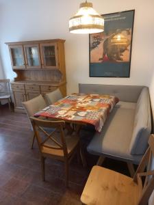 a dining room with a table and chairs and a couch at Appartamento Spormaggiore in Spormaggiore