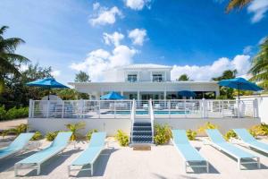 Driftwood VillageにあるCaribe Sun - Modern Villa with Pool! Walk to the Rum Point Club & Kaiboの青いラウンジチェアと青いパラソルのあるリゾート +31枚の写真