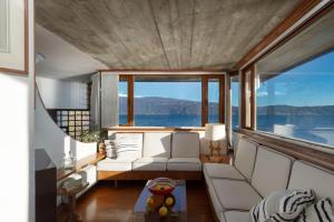 a living room with a white couch and a large window at Villa Anna in Toscolano Maderno