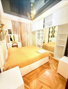 a bedroom with a large bed and a chandelier at Квартира в центре Тбилиси in Tbilisi City