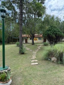 a stone path in a yard with a house at Complejo Sol Mediterraneo in Cosquín