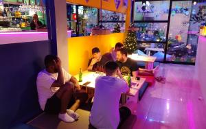 a group of men sitting at a table in a bar at RoXx Social Hostel in Bangkok