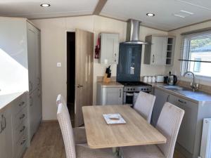 a kitchen with a table and chairs in a kitchen at Deblisa in Longtown