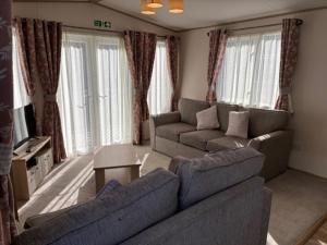 a living room with two couches and a tv at Deblisa in Longtown