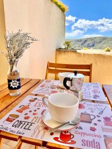 a table with a cup and a tea pot on it at Hostdomus - Phil House in Finale Ligure