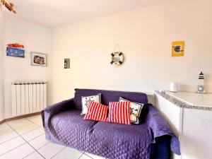 una sala de estar con un sofá púrpura con almohadas en Hostdomus - Phil House, en Finale Ligure 18 fotos más