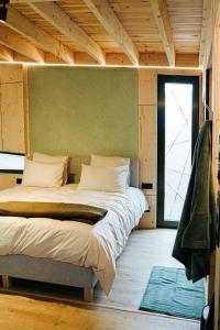 a bedroom with a large bed with a green wall at Bobble Mons in Mons