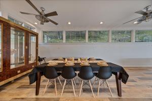 a dining room with a table with chairs and windows at Casa Mattia 4BR Luxury Mountain Home in Suffern
