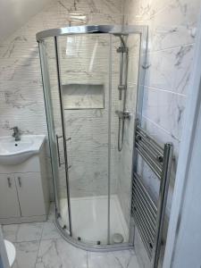a shower with a glass door in a bathroom at Comfort Rooms - East Croydon in South Norwood
