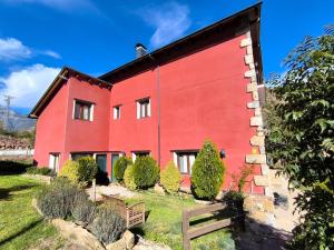 een rood gebouw met struiken ervoor bij Hotel Boutique La Casa del Río in Villanova