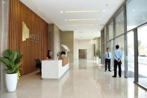 two men standing in the lobby of a building at The Vista Masteri Thao Dien N-Stay Apartment in Ho Chi Minh City