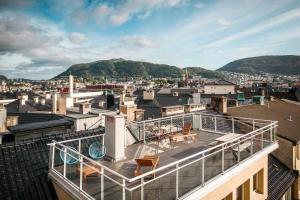 Un balcón con sillas y mesas en la parte superior de un edificio. en Torgalmenningen Town Square, Yet quiet, Elevator in building, en Bergen