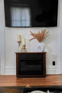 una chimenea con dos velas y un televisor de pantalla plana en 3 Bed Bath with yard and Fire Pit- Charming Small Town Exploring, en Bremen