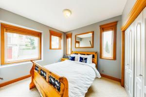 a bedroom with a wooden bed and windows at Tree Tops 13 in Big White