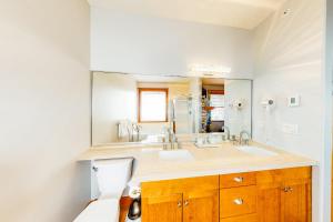 a bathroom with a sink and a large mirror at Tree Tops 13 in Big White +19 photos