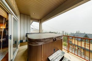 a balcony with a hot tub on a porch at Tree Tops 13 in Big White