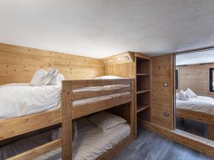 Dos literas en una habitación con paredes de madera. en Duplex rénové proche pistes, 6 pers, animaux bienvenus, Wi-Fi - FR-1-640-41, en Val Thorens
