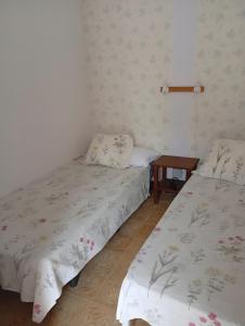 two beds in a room with a table at La Estrella in Agulo