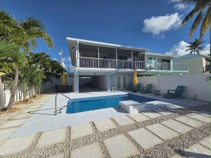 a house with a swimming pool in front of it at Direct access Canal front with Pool 2 bed 2 bath in Marathon