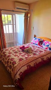 a bedroom with a bed with a stuffed animal on it at Apartment Exotica in Flic-en-Flac