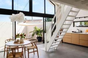 Una escalera blanca en una cocina con una mesa y sillas. en JOSY Atelier, en Ferrel 12 fotos más