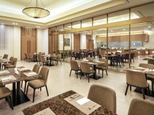 a restaurant with tables and chairs and a cafeteria at Mercure Ambassador Jeju in Seogwipo