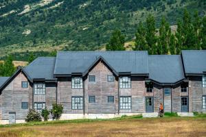 una grande casa in legno con tetto nero di Hotel Las Torres Patagonia a Torres del Paine