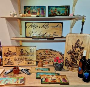 Una mesa con cuadros y otros objetos en un estante. en Atelje Mlin Umetnin Retreat, en Šentjur