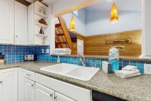 een keuken met een wastafel en blauwe tegels bij Neptunes Palace B-2 in Saint George Island +13 foto's