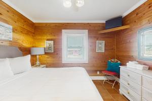 een slaapkamer met een wit bed en een rode stoel bij Neptunes Palace B-2 in Saint George Island