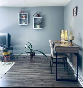 a room with a desk and a table and a tv at 1 BR Cozy Apartment with Fire Pit Short walk to town in Nappanee