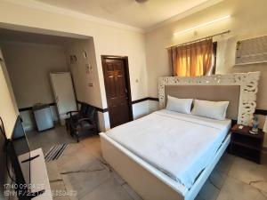 a bedroom with a large white bed in a room at Candolim beach apartment goa in Candolim
