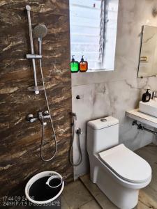 a bathroom with a shower with a toilet and a sink at Candolim beach apartment goa in Candolim +8 photos